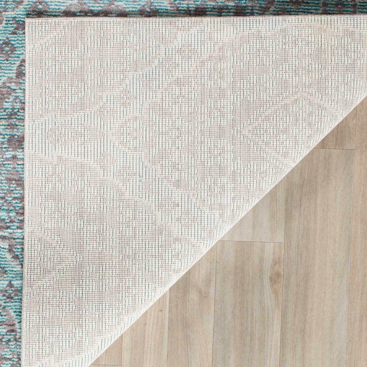 Light woven backing and a neatly finished edge complement the rug's patterned surface.