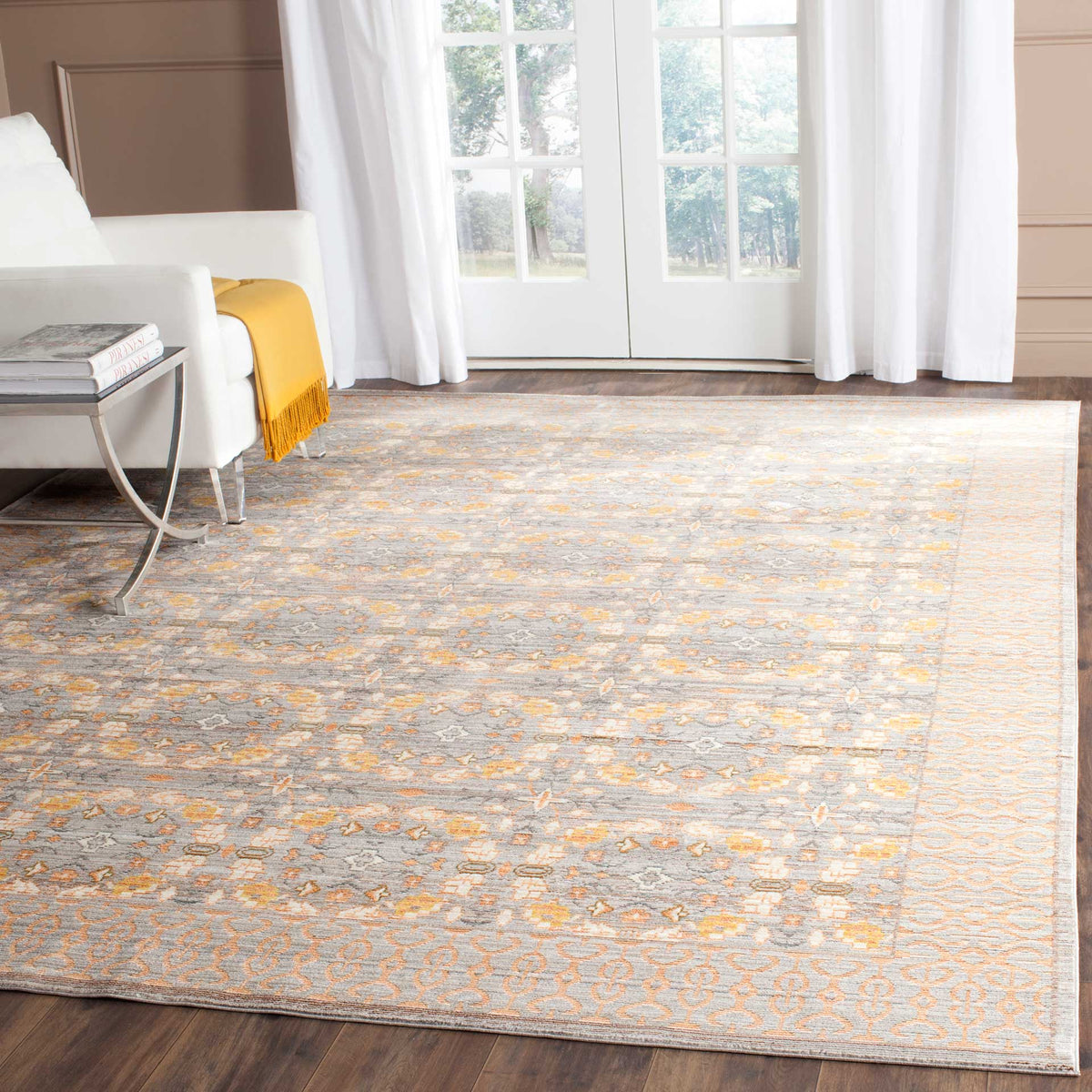 Faded gray and peach patterned rug adds soft color and ornate detail to a living room