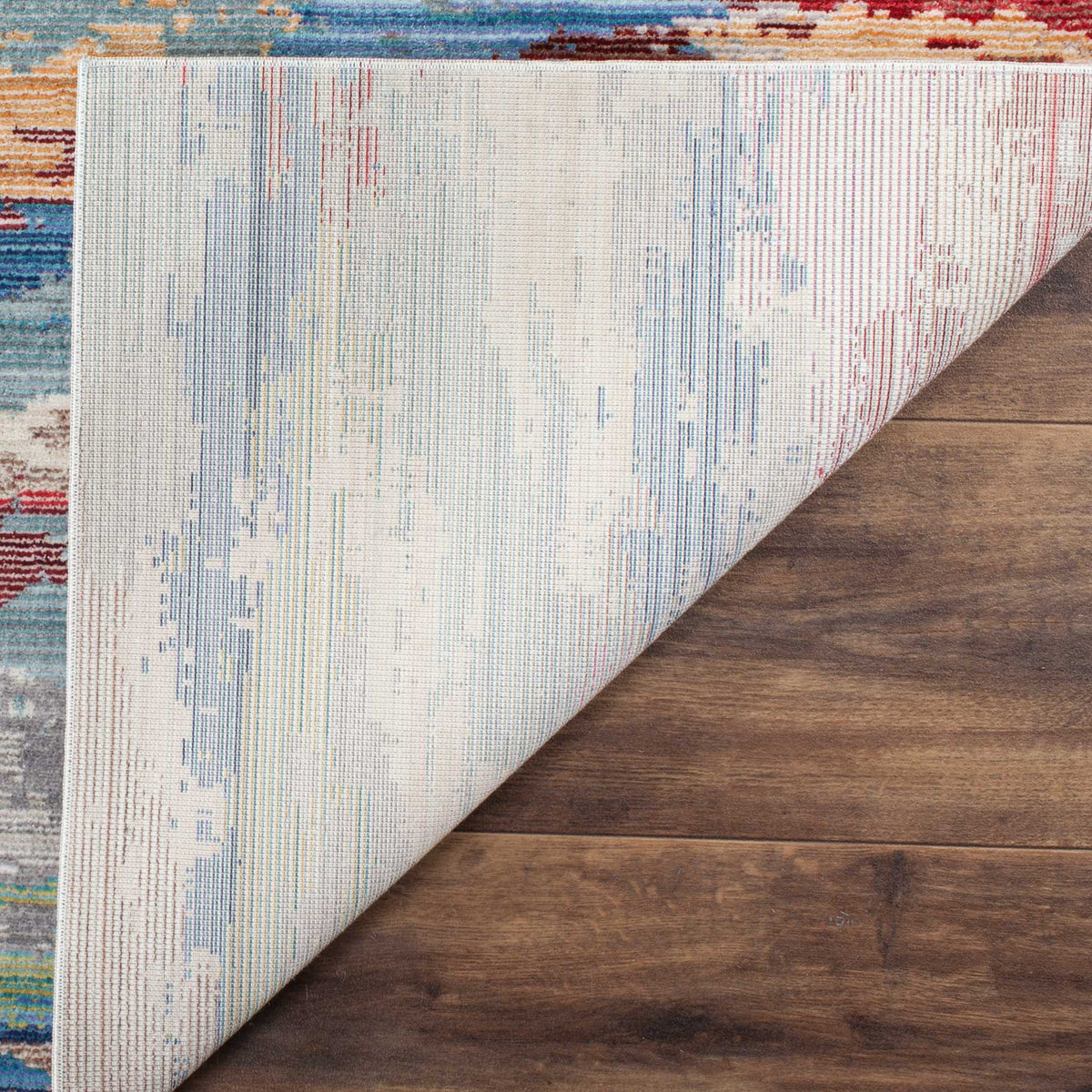 A pale woven cotton backing complements the rug's richly colored abstract surface.