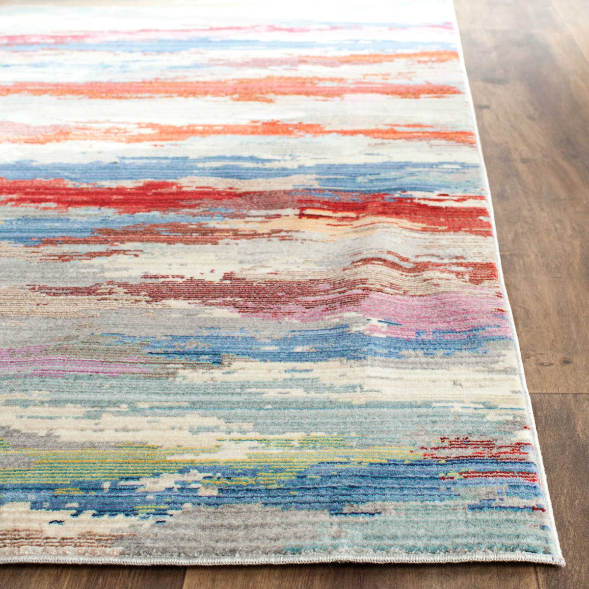 A neatly bound edge frames blue, coral and crimson streaks across a low-profile pile.