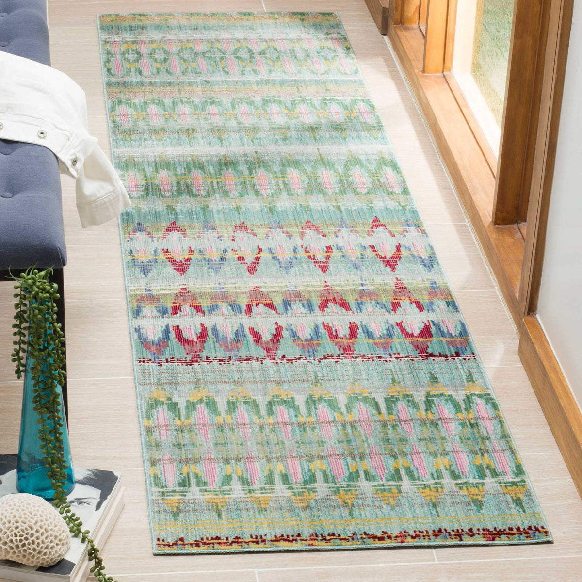 A light blue runner brings lively red, pink and green geometric bands to a bright living space.
