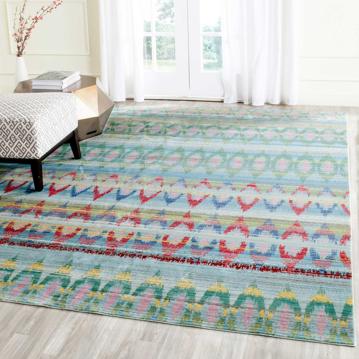 A colorful geometric rug brings light blue tones and vivid red accents to a serene bedroom.