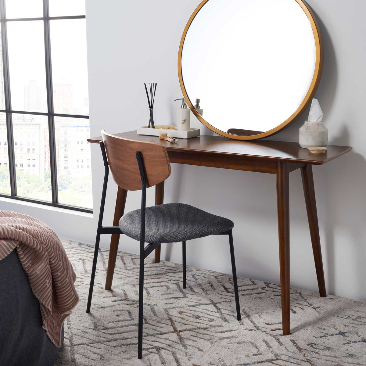 A walnut-finished vanity table offers space for a mirror and everyday essentials