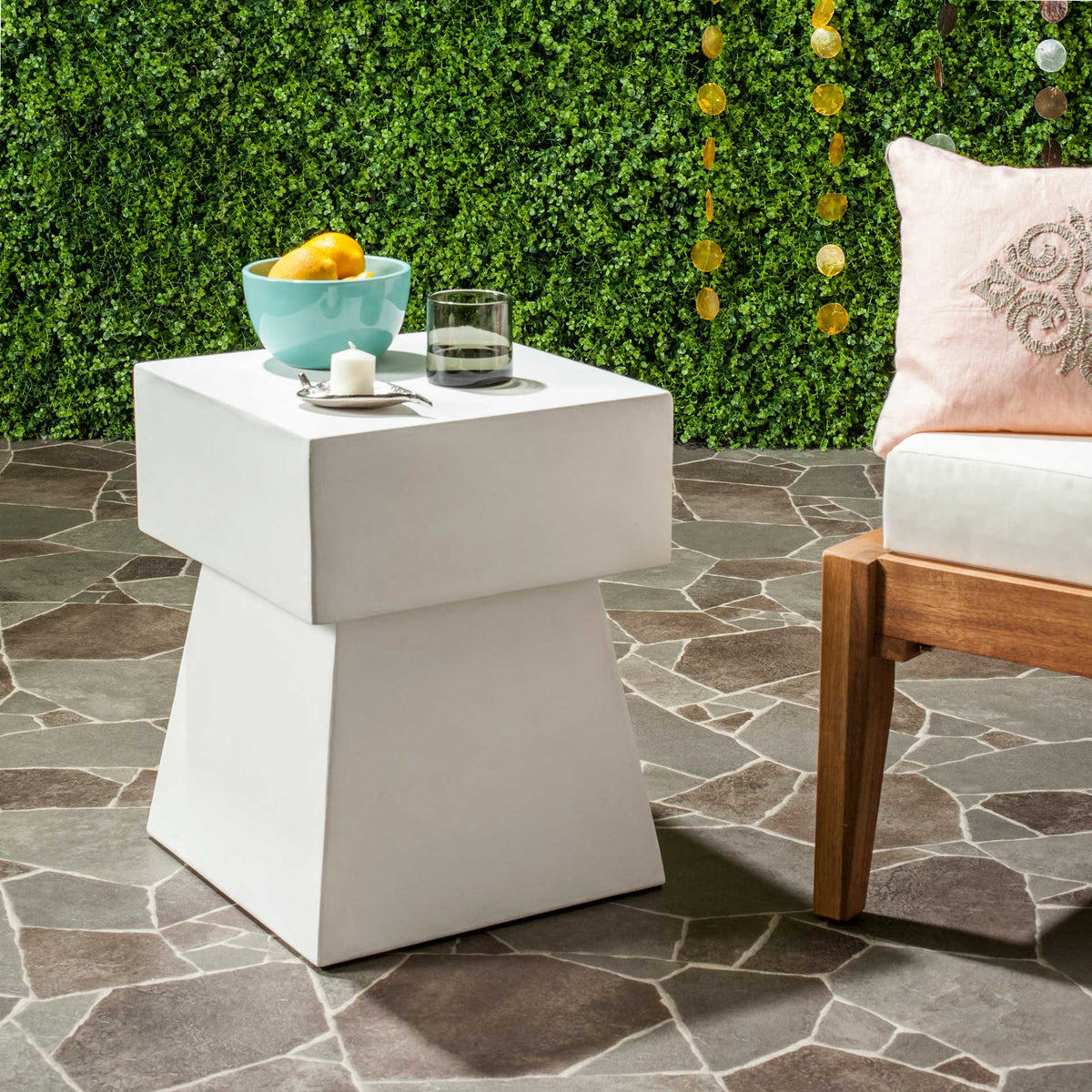 Ivory concrete side table offers a sturdy perch for refreshments beside patio seating