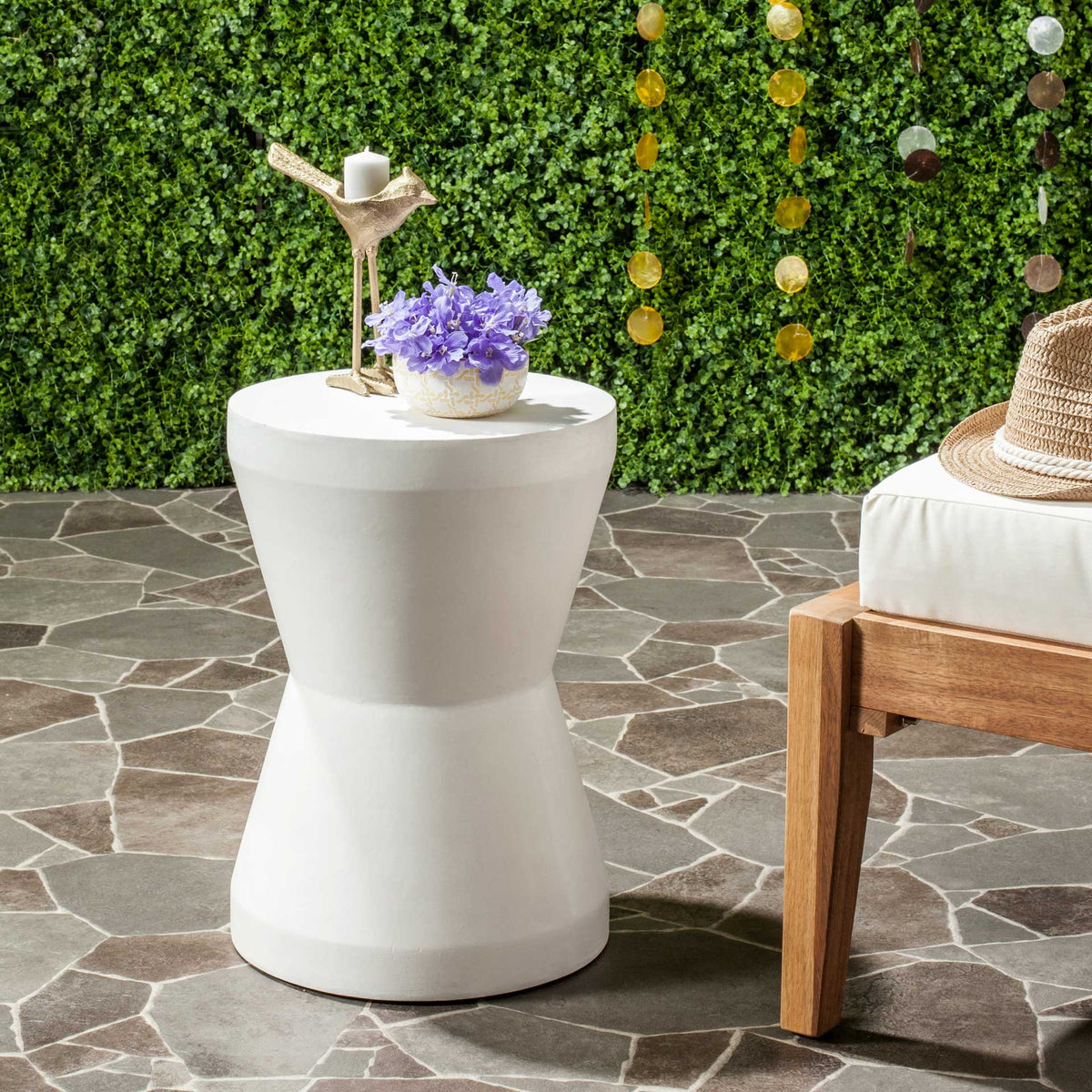 Ivory accent table offers a smooth round surface for flowers and candles by outdoor seating