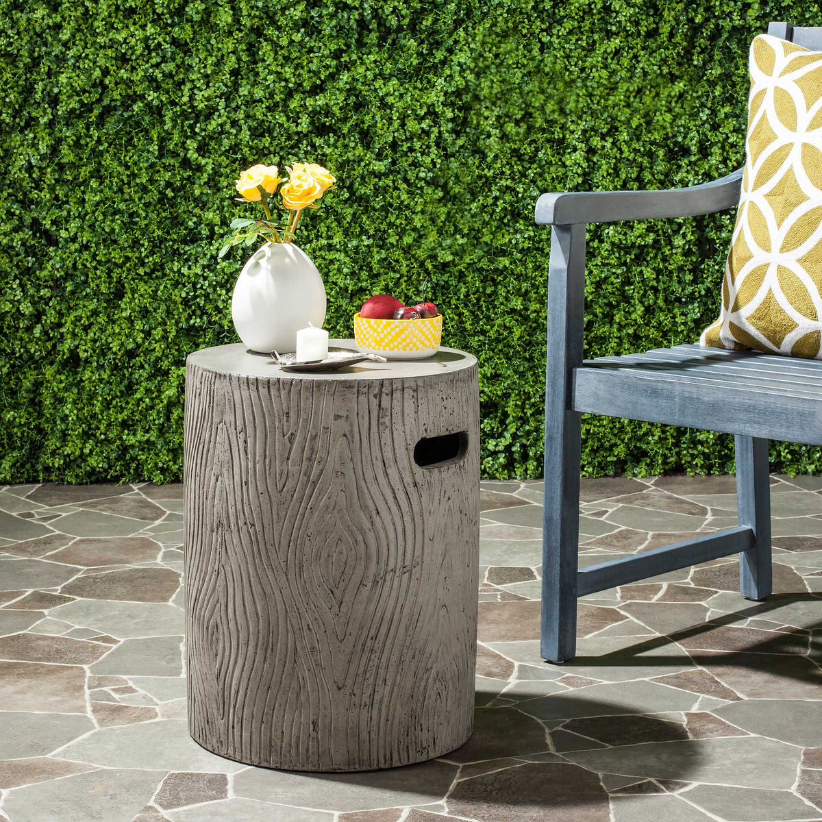 Dark gray concrete table serves as an outdoor perch for flowers and refreshments