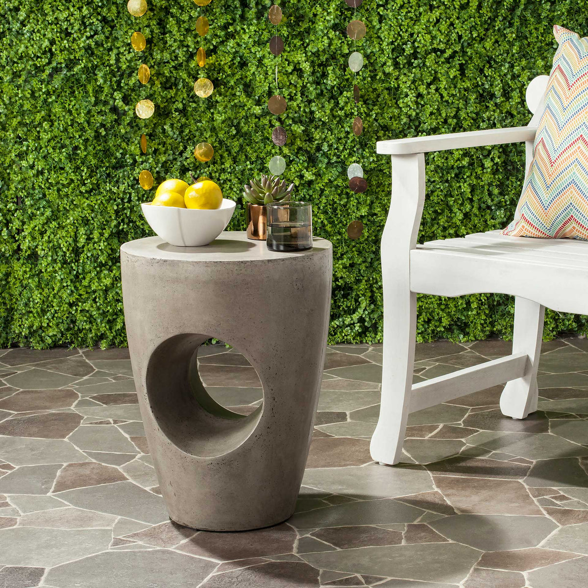 Dark gray concrete accent table with a sculptural cutout and a round top for patio decor