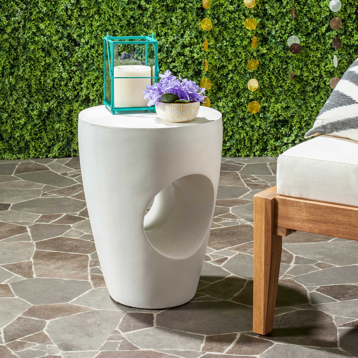 Ivory concrete accent table with a circular cutout and a round top for patio accents