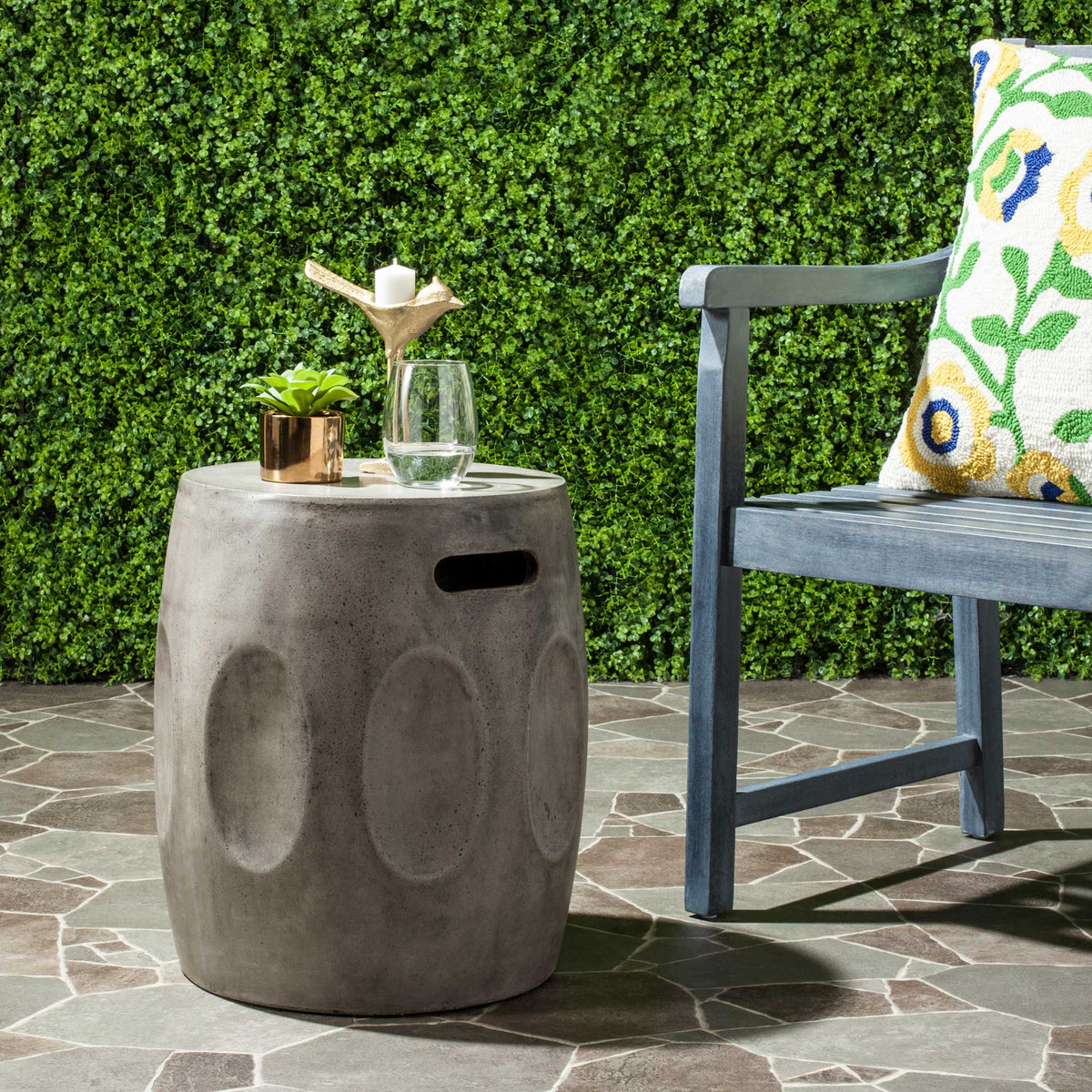 Dark gray concrete table adds sculptural texture and a handy surface to a patio seating area