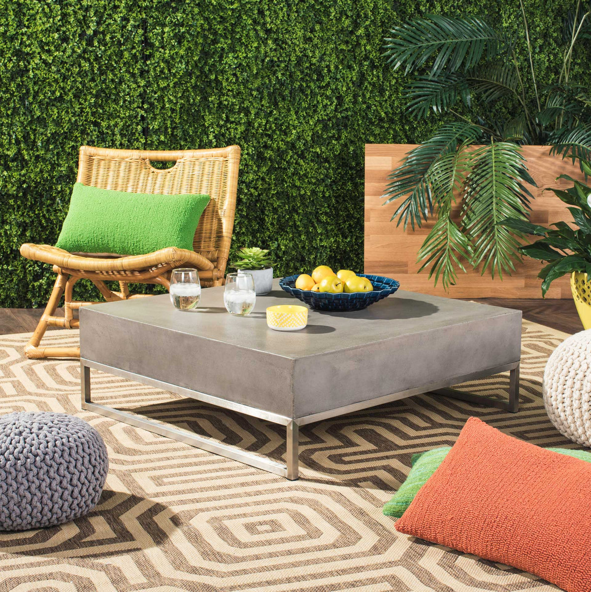 A generous concrete tabletop and slim metal frame create a gathering spot for outdoor lounging.