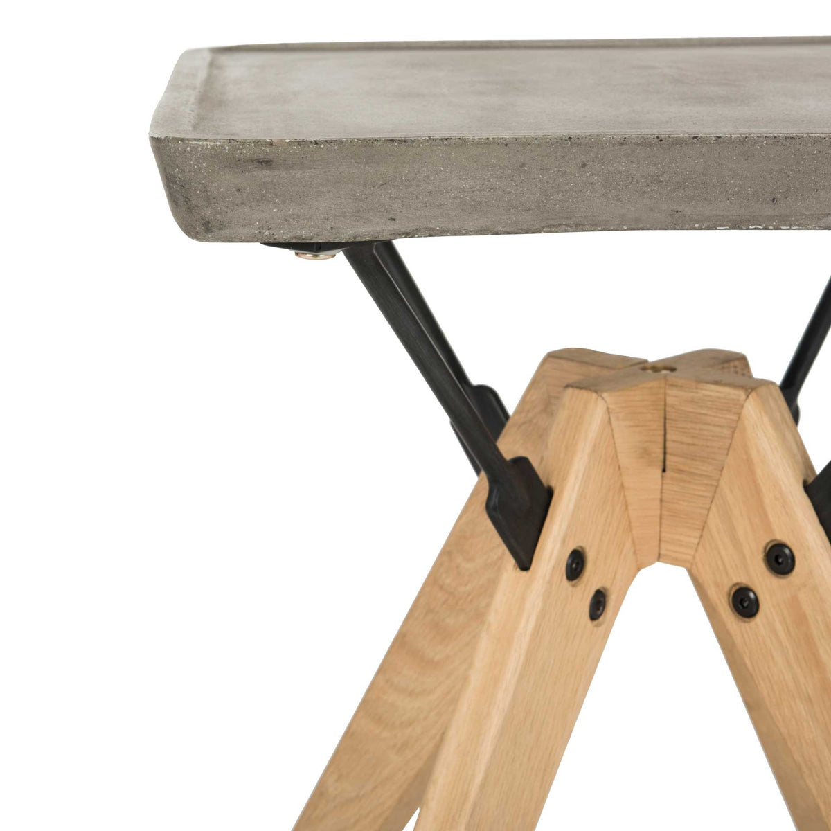 Bolted oak leg joints meet angled black steel braces beneath the thick concrete tabletop