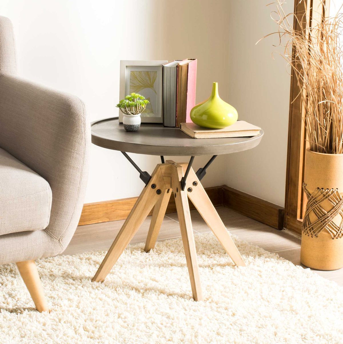 A round concrete side table brings industrial texture and warm oak legs to a cozy living room.