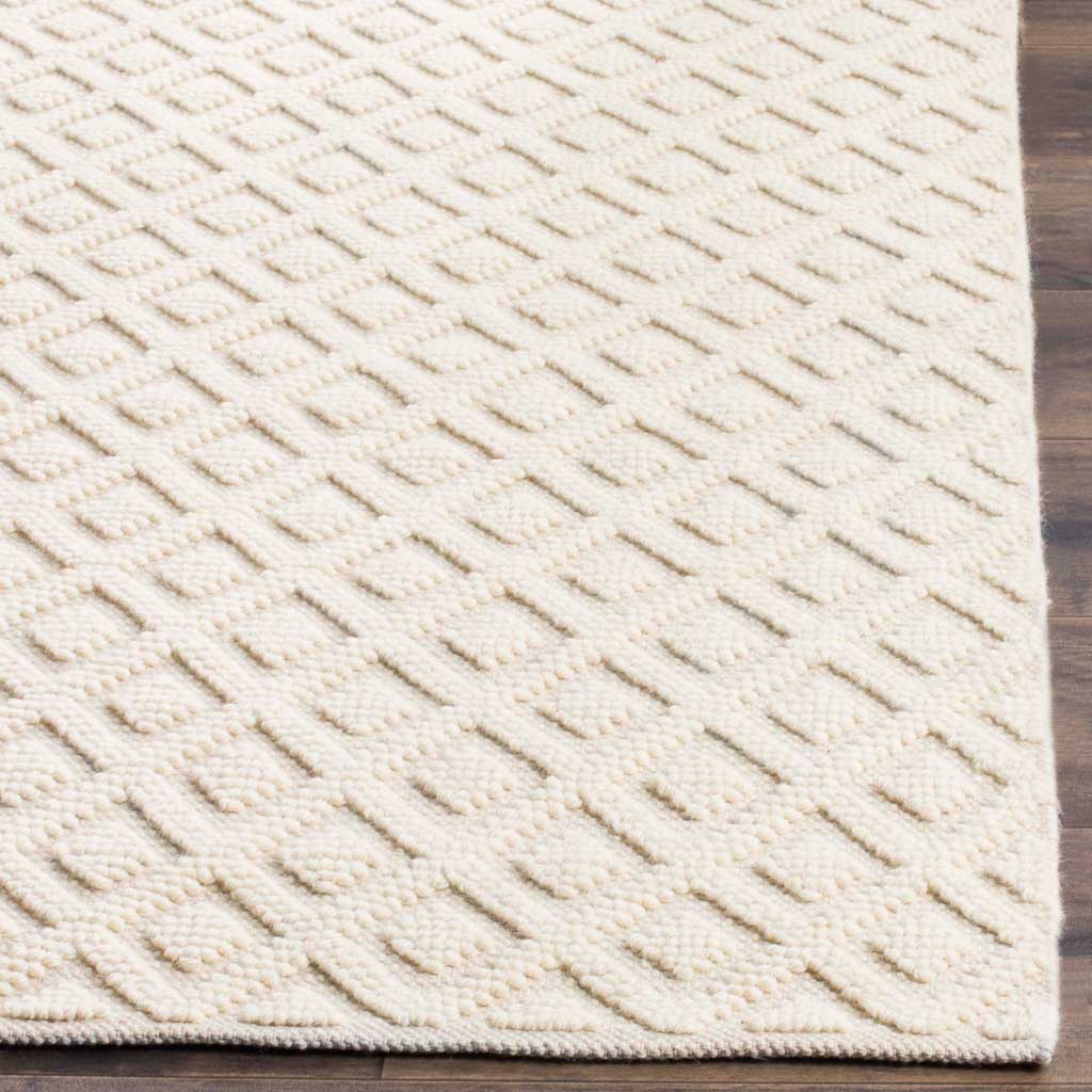 Raised diamond motifs and a neatly finished edge add tactile appeal to the ivory rug.