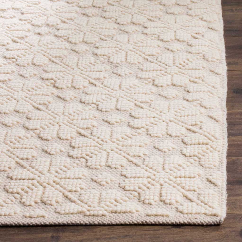 Raised geometric motifs and a neatly finished edge lend this ivory rug tactile character