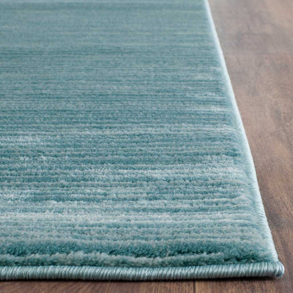 Soft aqua pile and a neatly bound corner reveal subtle tonal texture