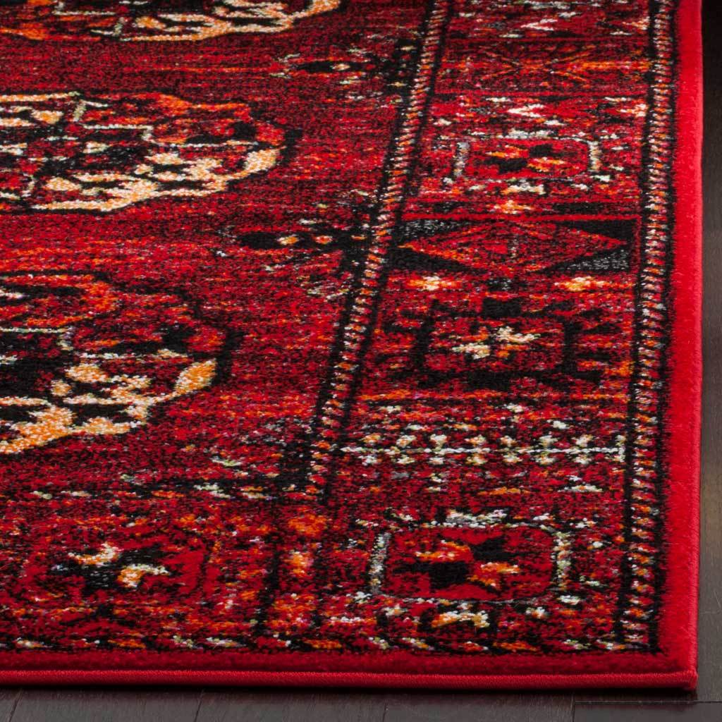 Red binding completes the intricate black and ivory motifs along the rug's edge
