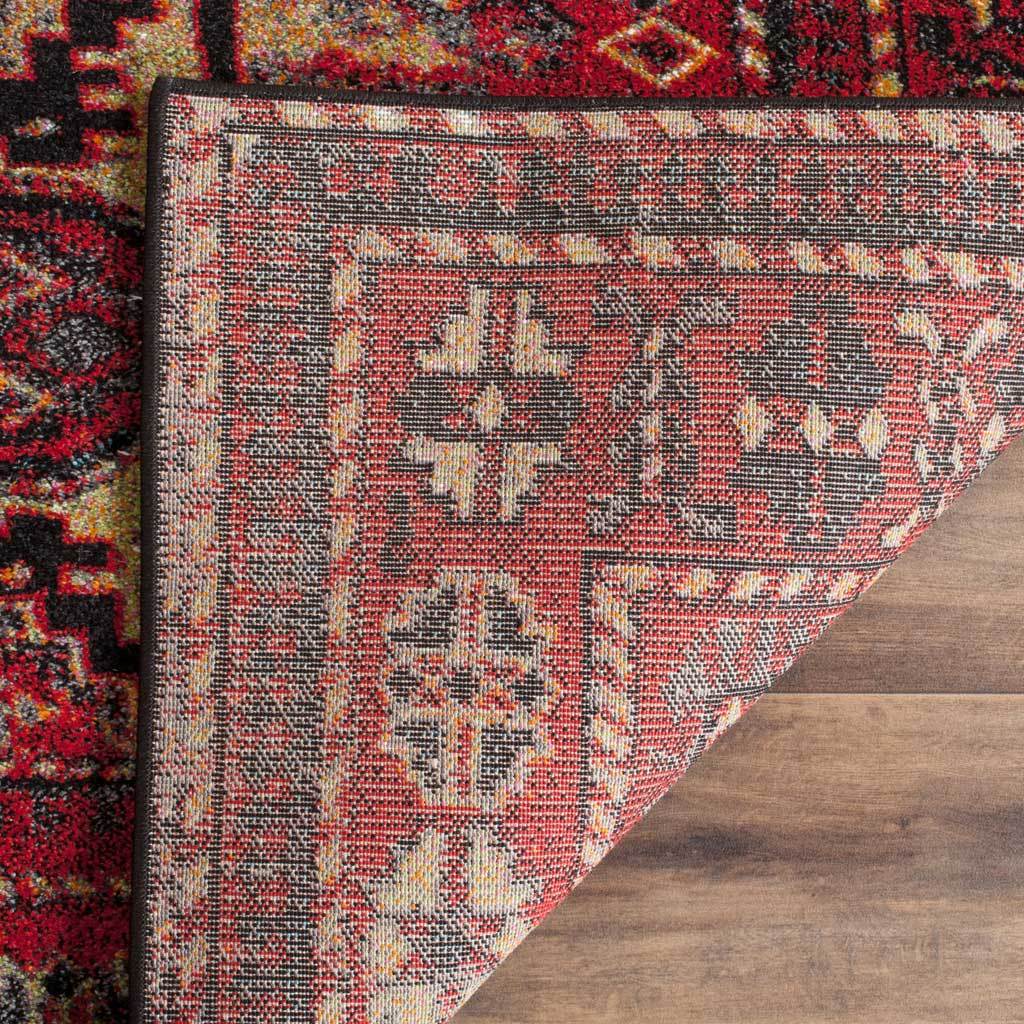 Patterned woven underside and dark edge binding finish the red geometric rug