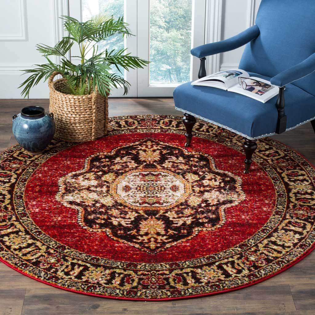A vivid red field and ornate central medallion add warmth beneath a blue accent chair.