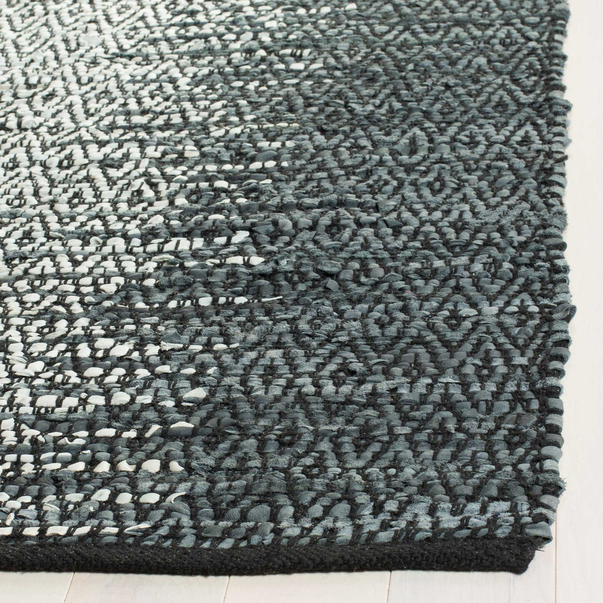 Leather strips weave a textured transition from ivory to charcoal diamonds