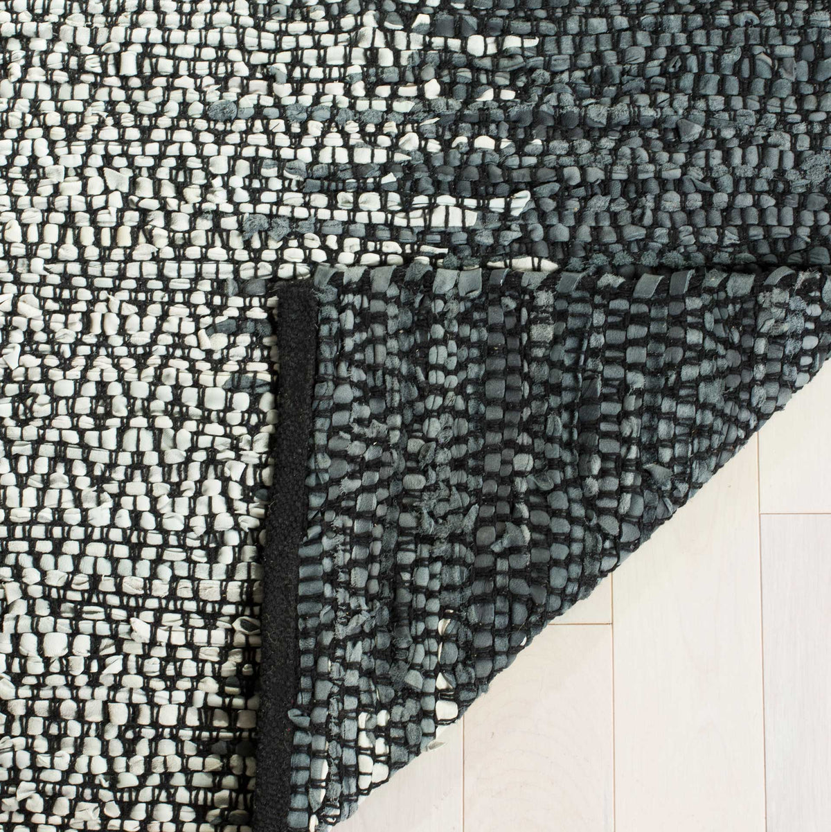 Folded reverse highlights a charcoal weave beneath the pale diamond pattern