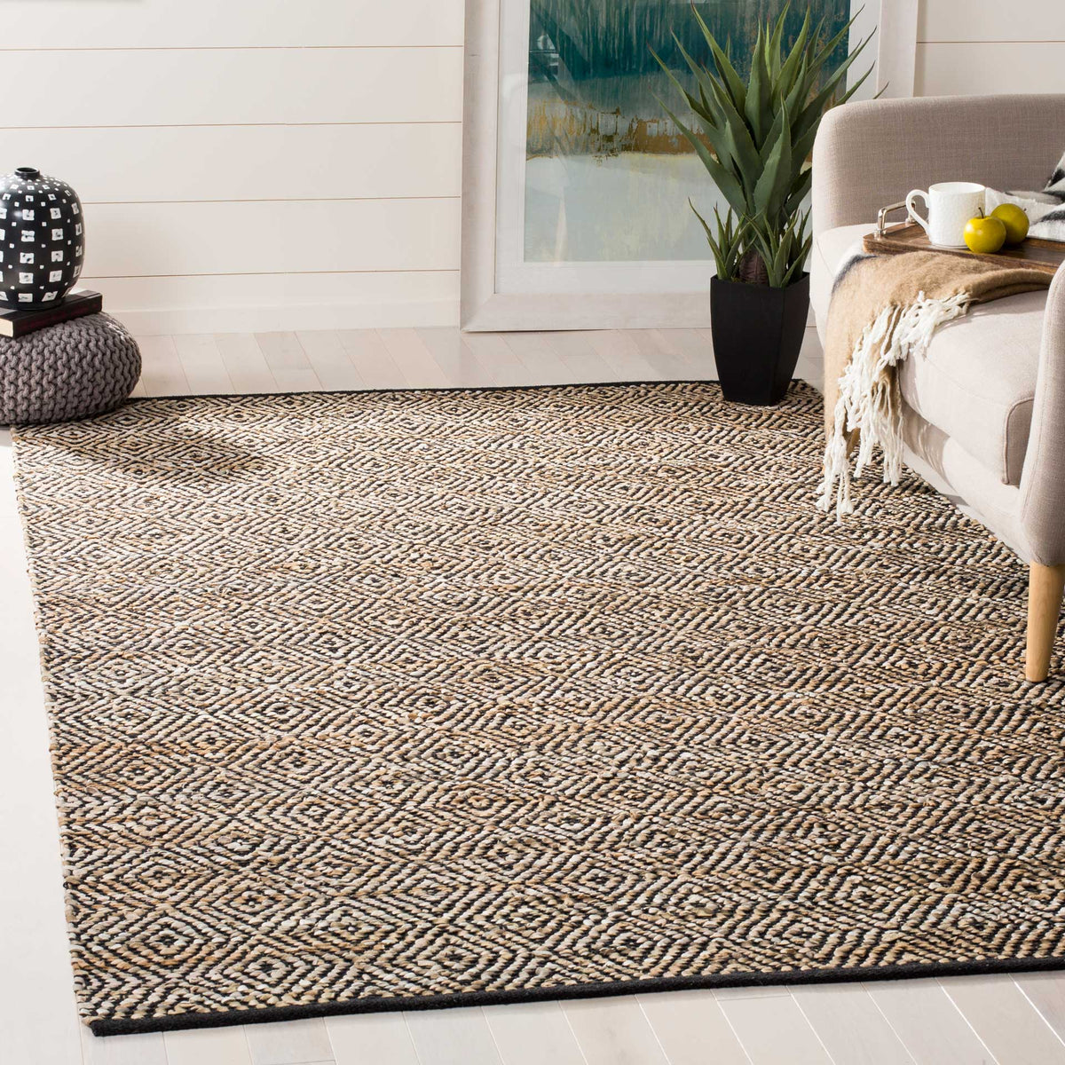 Black diamond motifs animate a beige rug beneath a neutral sofa
