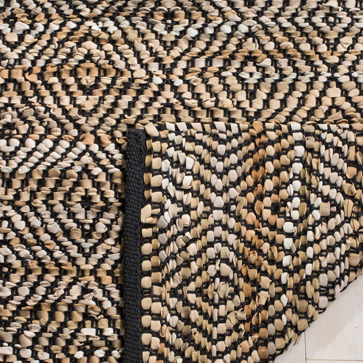 Folded woven underside reveals the rug's black-and-beige diamond texture