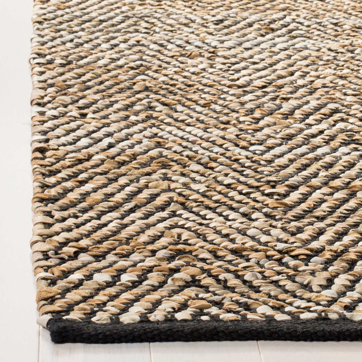 Beige and black leather strips interlace into tactile herringbone ridges