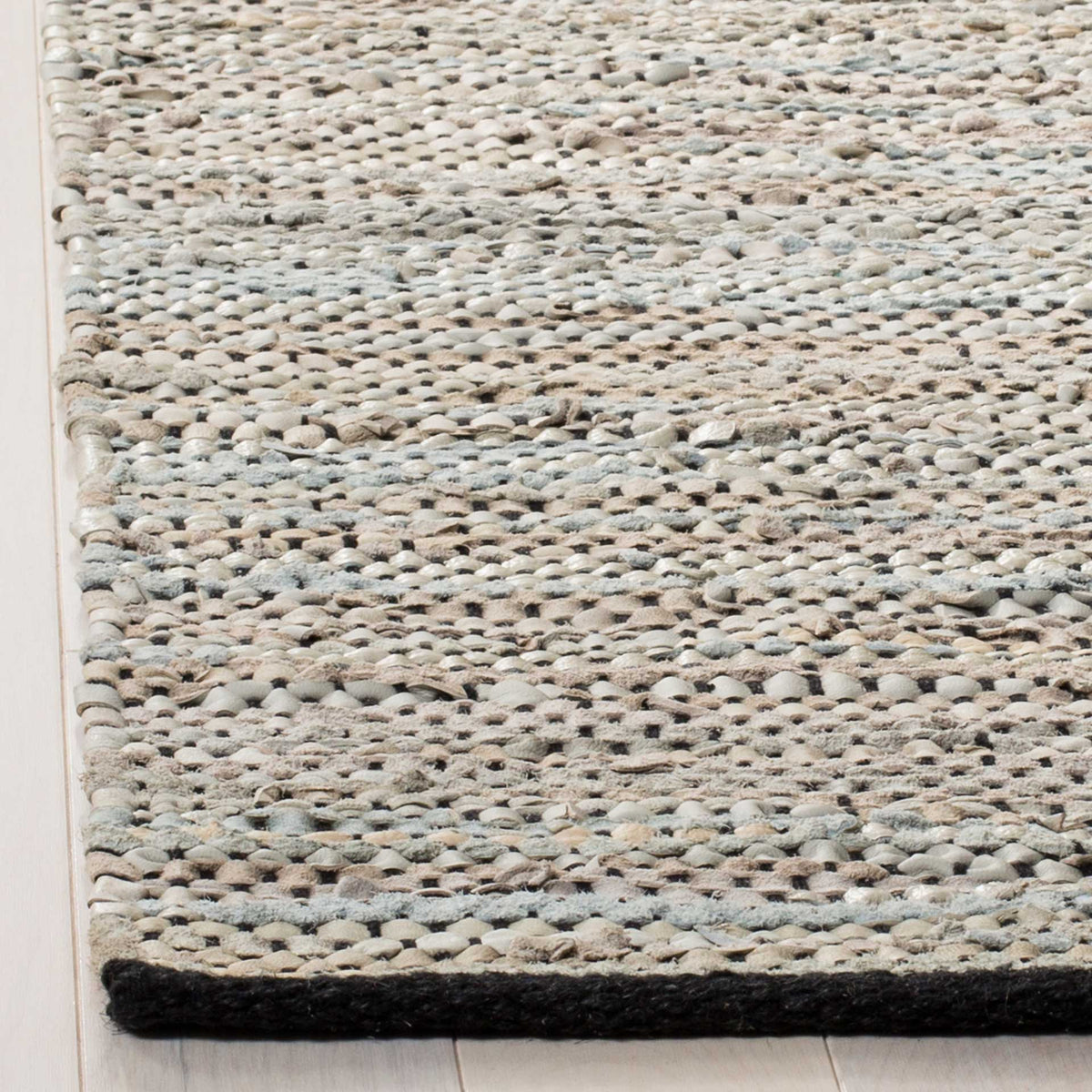 Cream and beige leather strips form a thick woven edge with dark binding