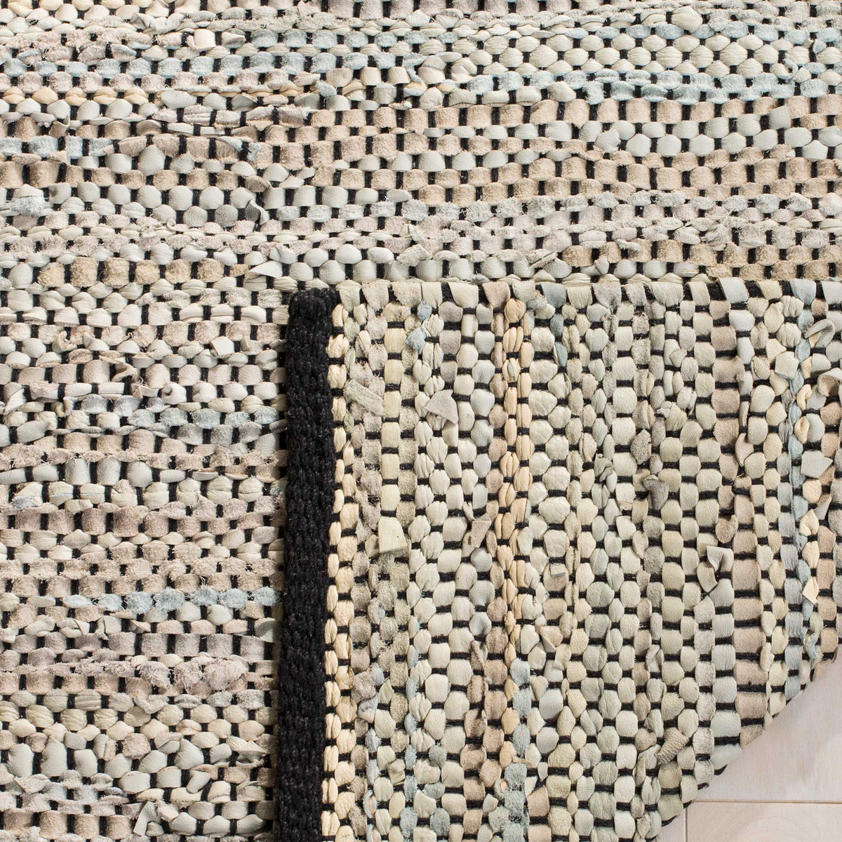 Folded underside reveals the rug's intricate natural leather weave