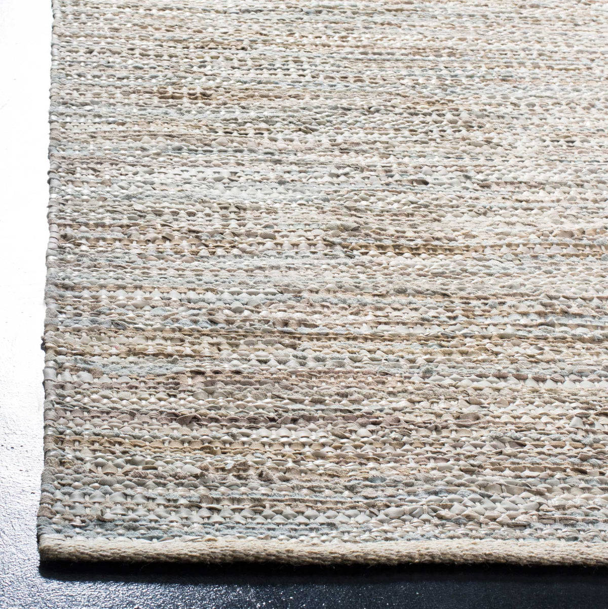 Cream and tan leather strips create rich texture along the woven edge