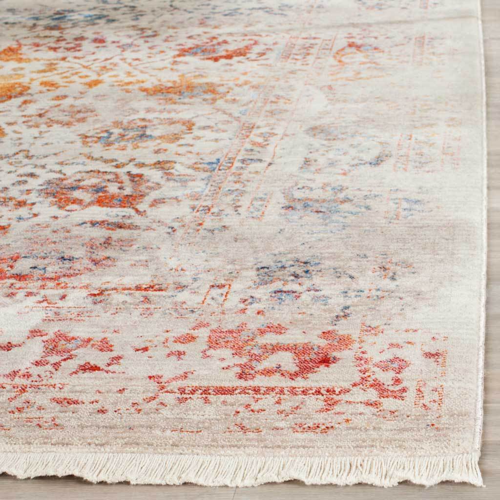Cream fringe finishes the softly faded orange and blue floral rug