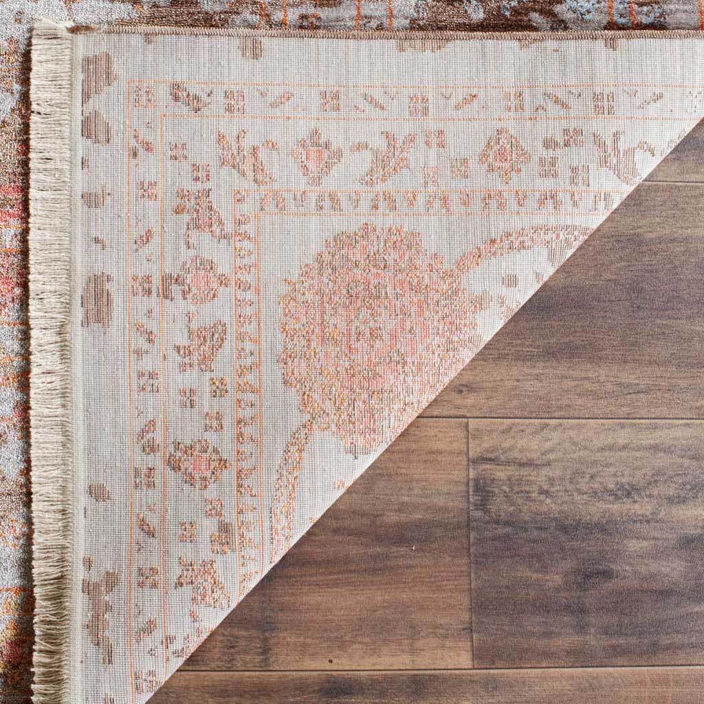 Patterned cotton backing and cream fringe finish the floral rug