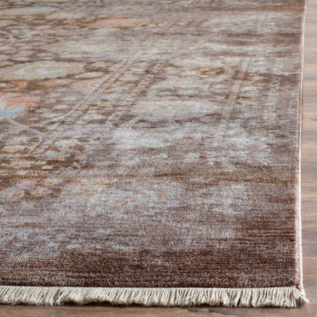 Ivory fringe lines the richly shaded brown floral rug