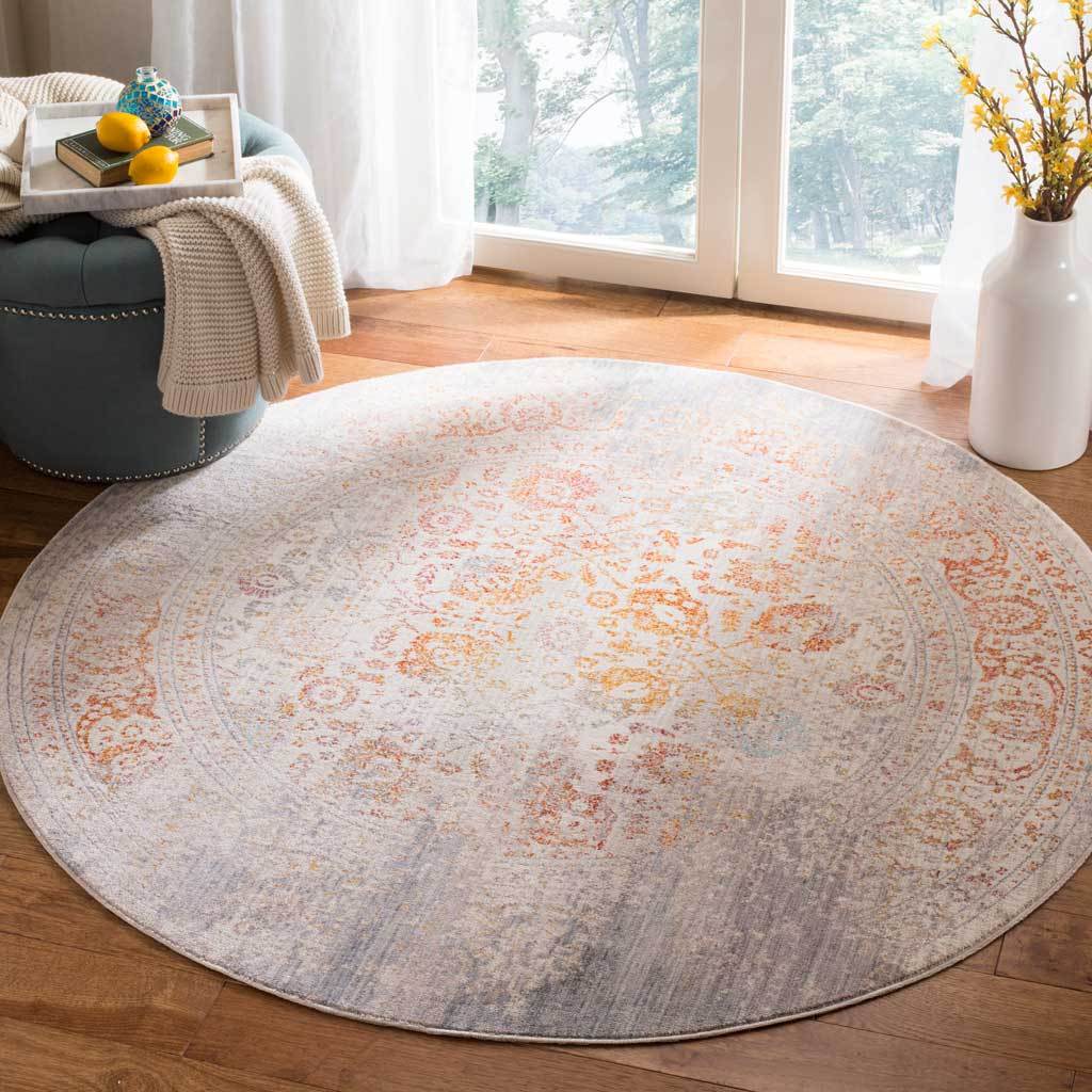 Pale gray and warm rust floral accents bring understated color to this round rug.