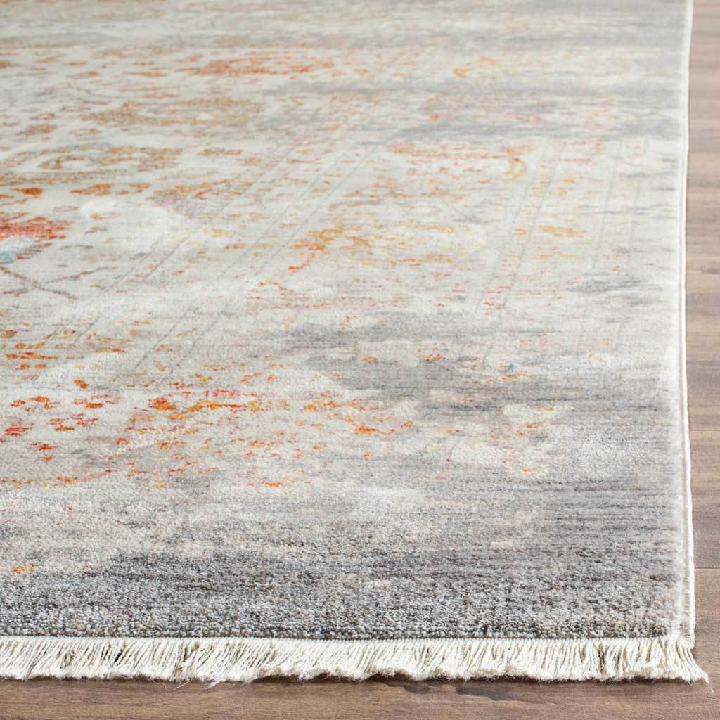 Light fringe softens the edge of the pale gray and orange floral rug