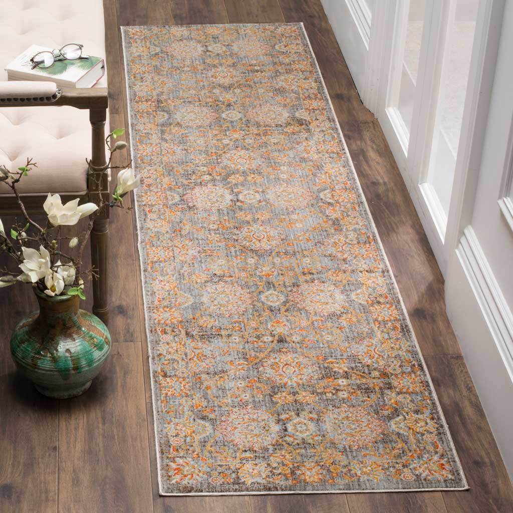 Weathered neutral runner layers gold and pale blue botanical motifs over a light brown ground