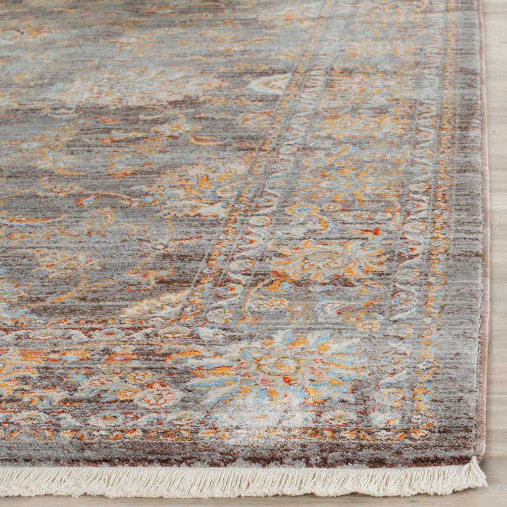 Ivory fringe accents the light brown rug's delicate floral border