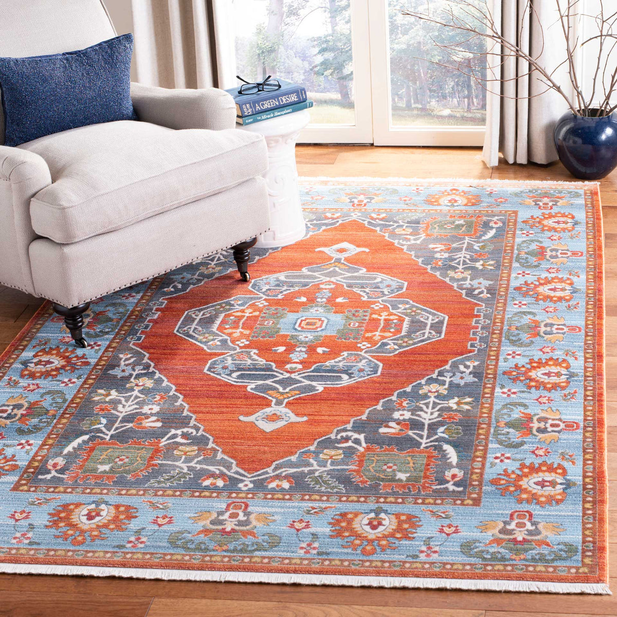 Rust and blue medallion rug brings lively color beside a cream sofa