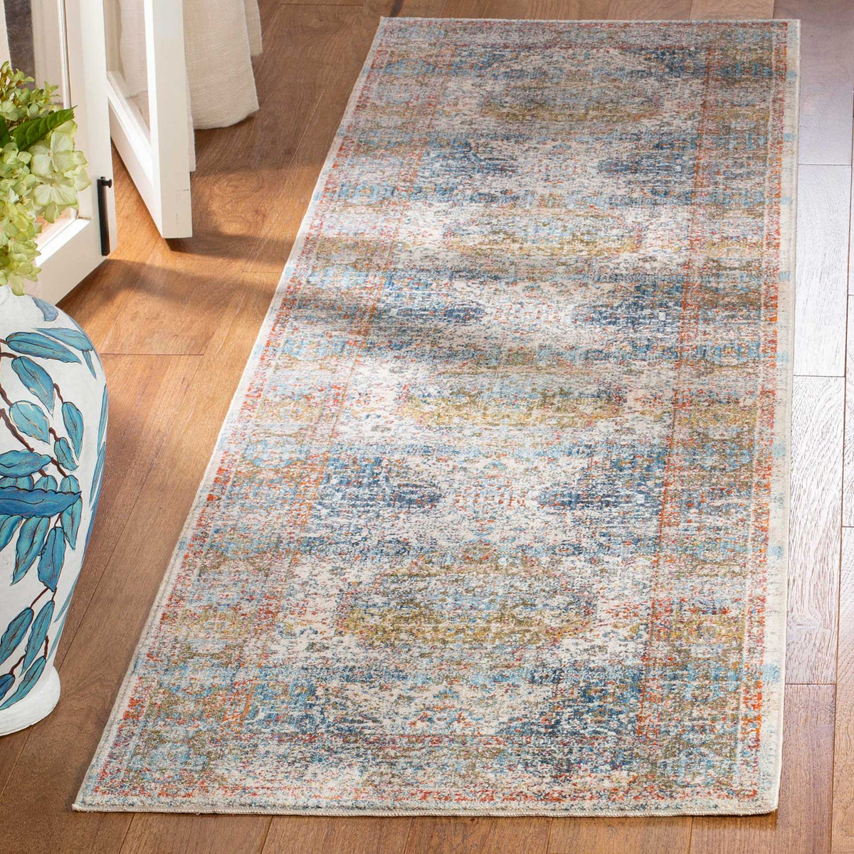 Cream and blue runner layers softly worn floral medallions and subtle terracotta details