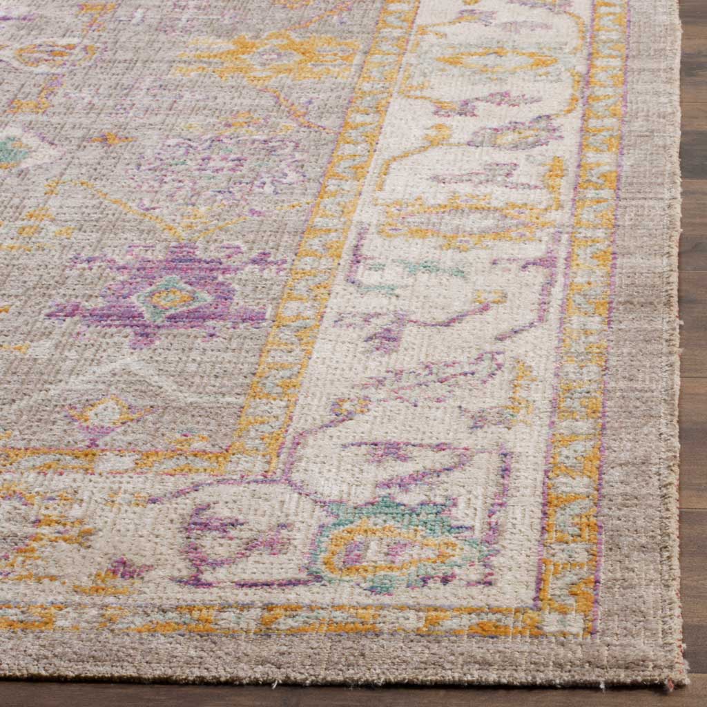 A cream floral border frames the textured gray rug, accented with violet, gold, and teal
