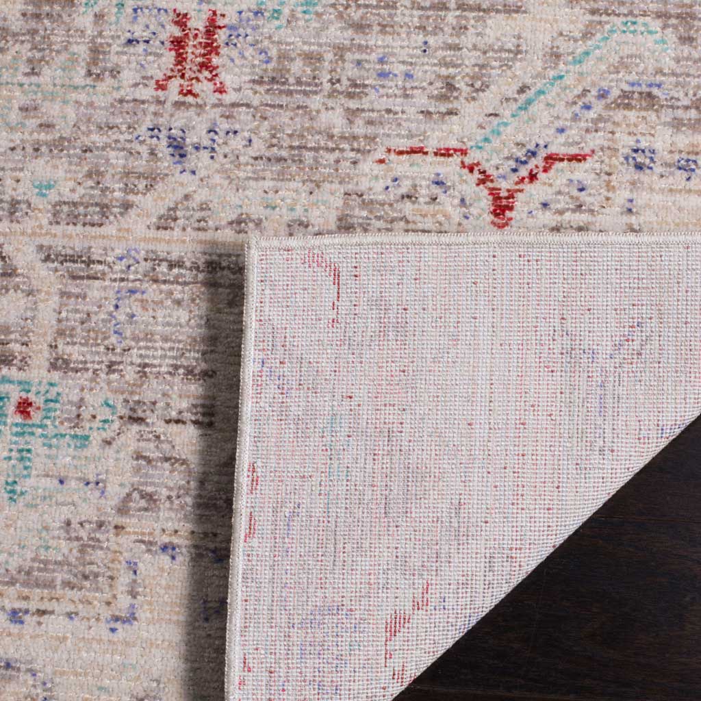 A folded corner reveals the woven underside beneath the rug's softly faded pattern.