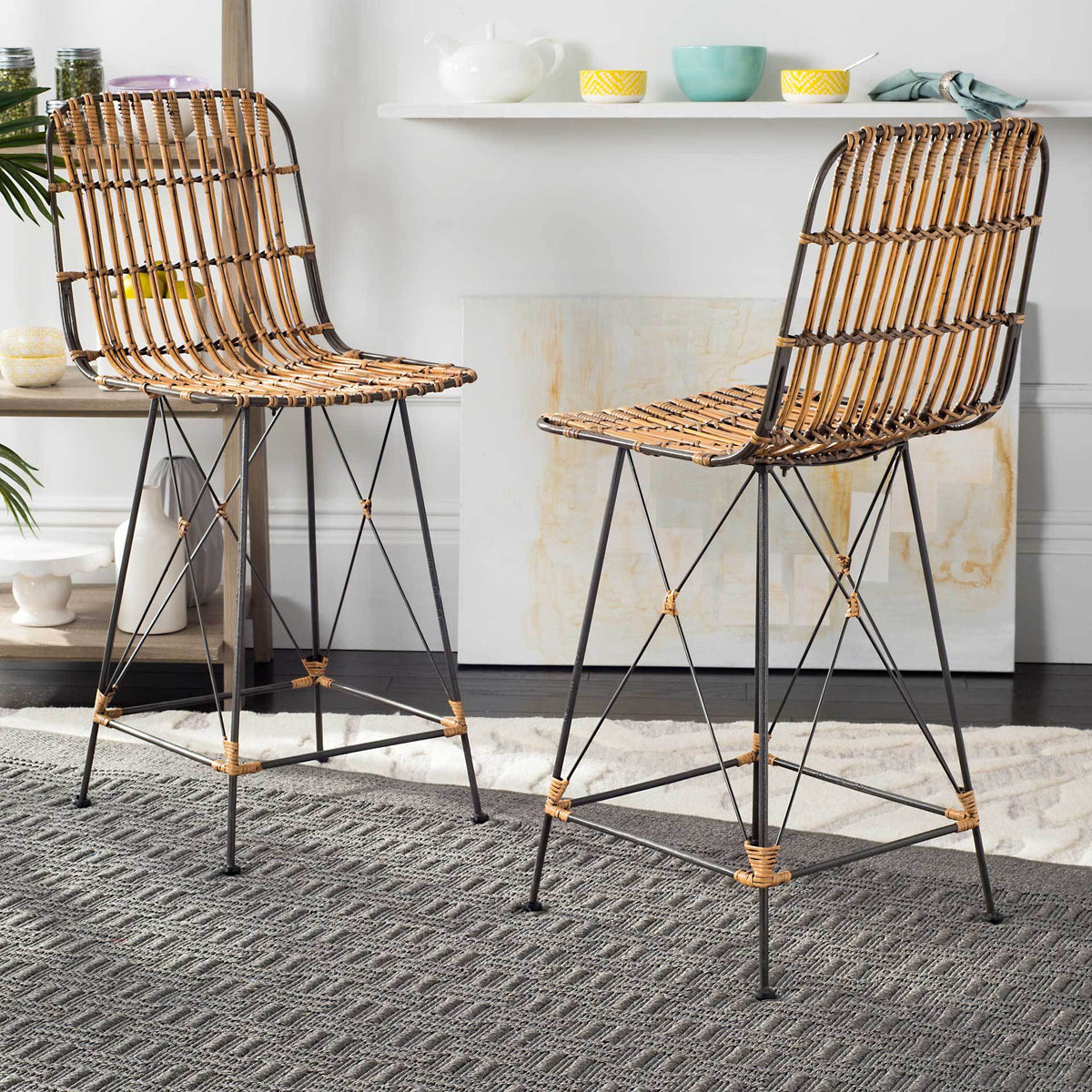 Two natural brown rattan counter stools add woven texture and slender black iron lines to a bright space