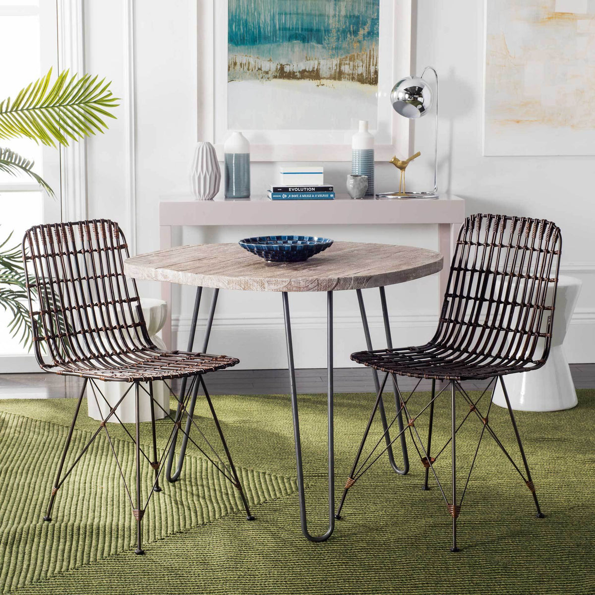 Two rich brown rattan chairs add woven texture and sculptural metalwork to a dining space.