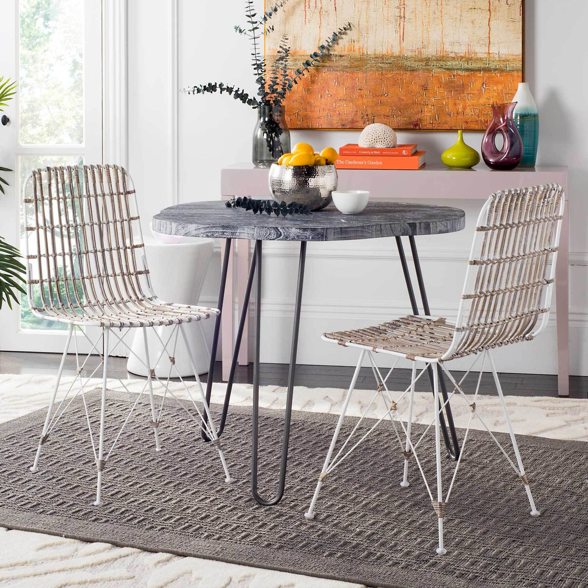 Two whitewashed wicker chairs add soft natural texture and airy metalwork to the dining area.