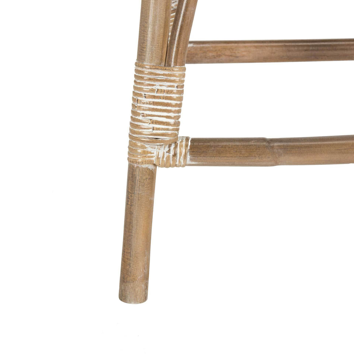 Tapered rattan leg joins the counter stool's low footrest at a tightly wrapped joint
