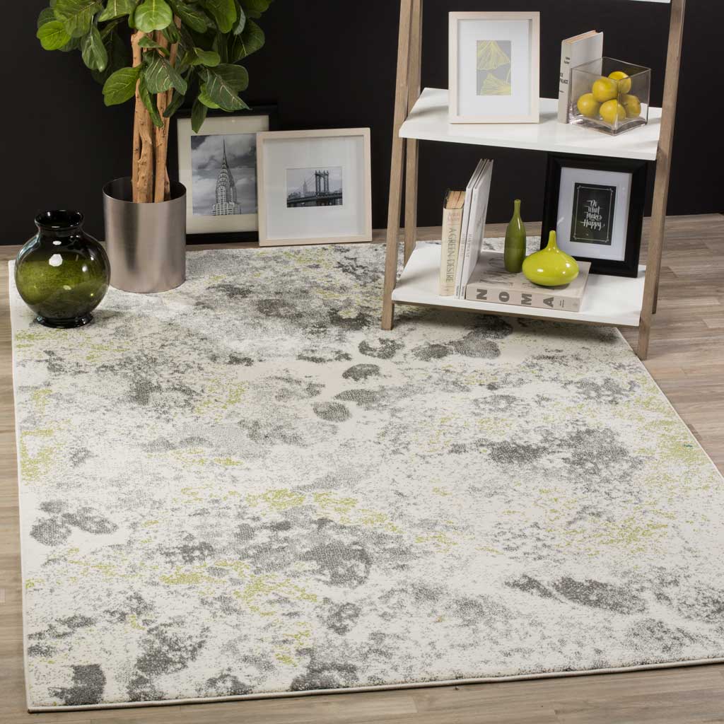 Smoky gray shapes and pale lime accents bring artistic color to a soft ivory rug.