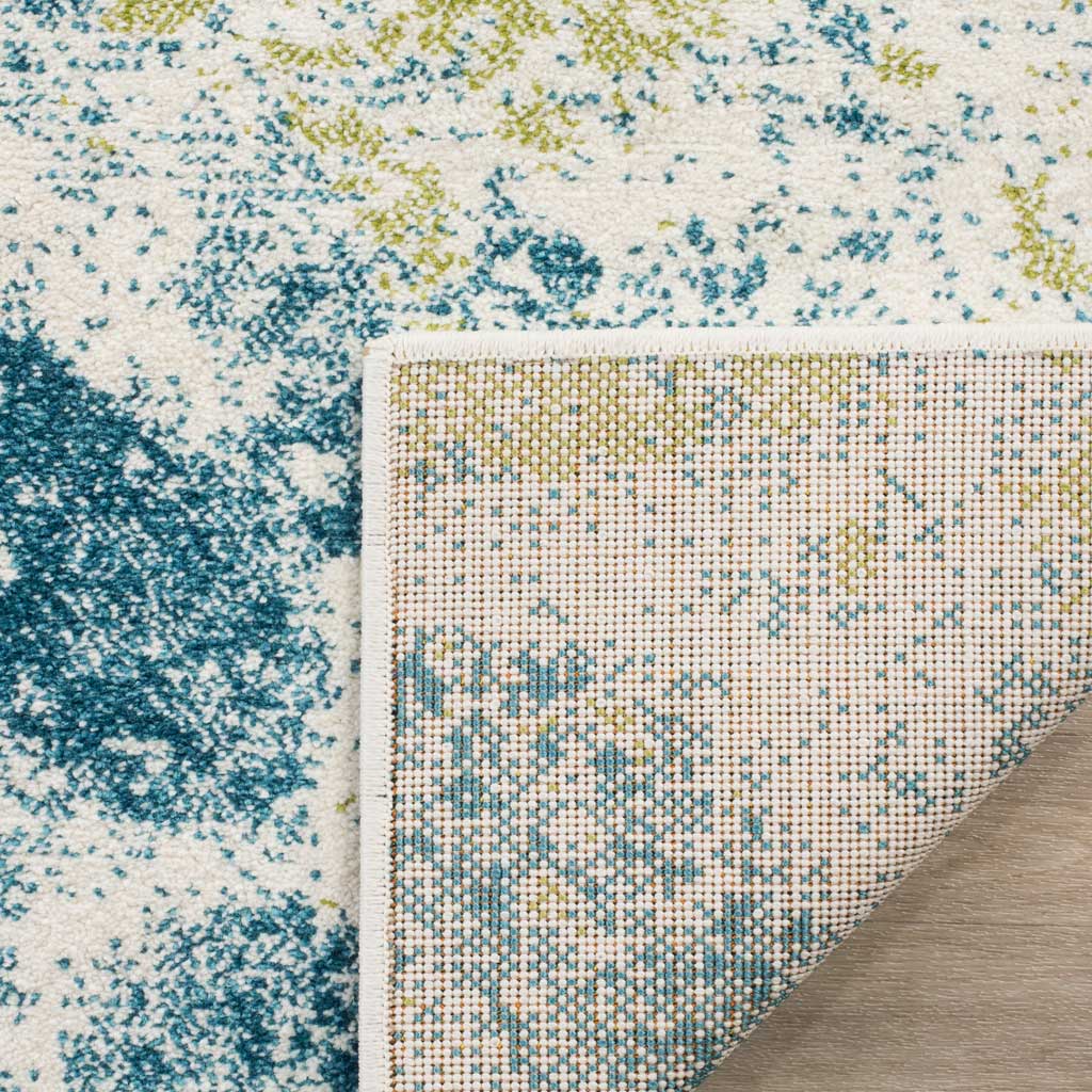 A woven underside and neatly finished edge support the ivory rug's blue and gold pile.