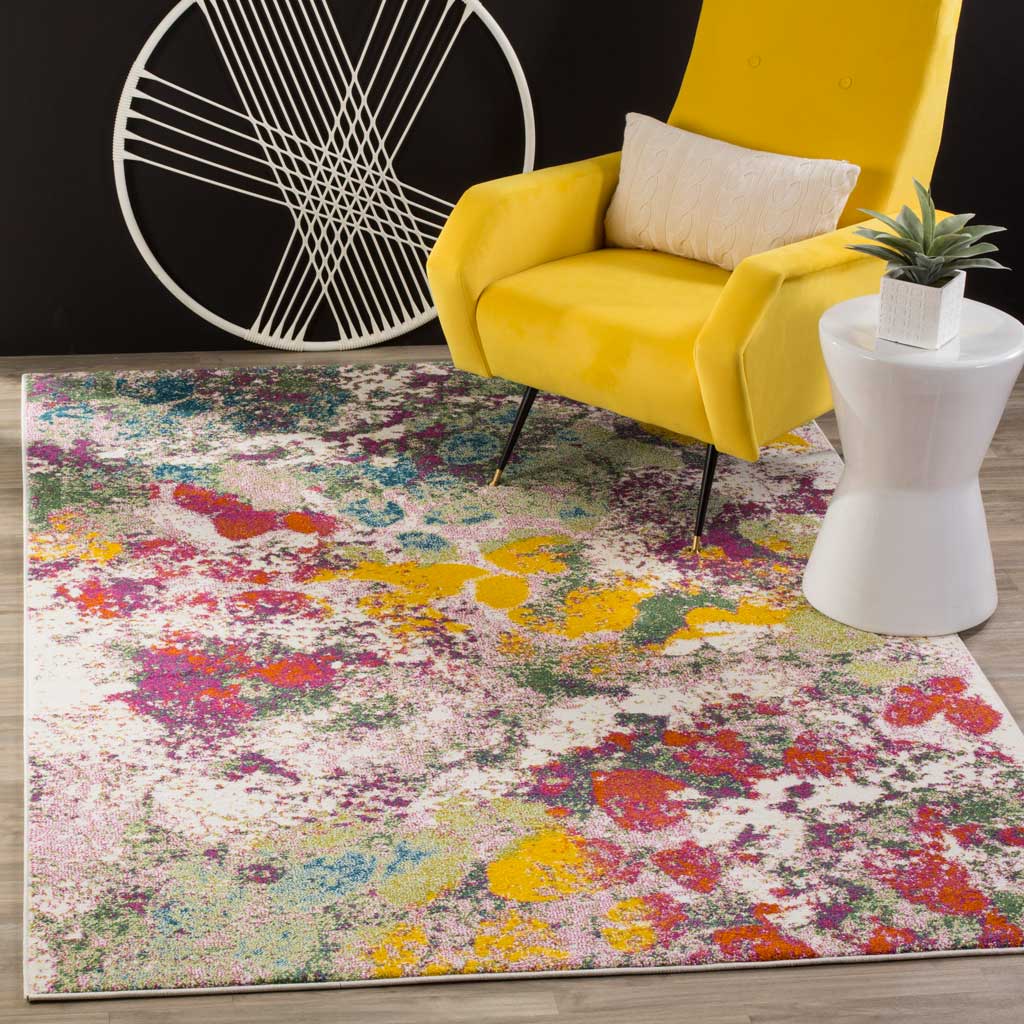 Bright rose, green, and yellow splashes enliven the ivory rug beneath a golden accent chair.