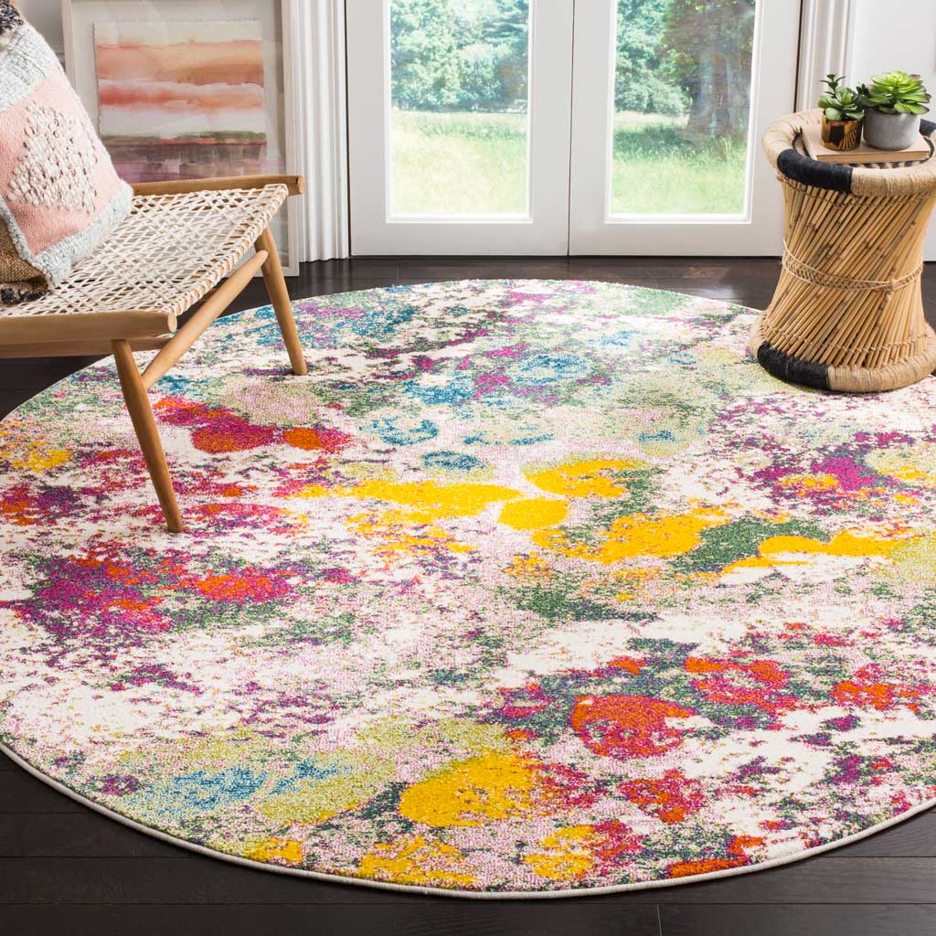 Round rug adds lively rose, green, and yellow color beside woven furniture